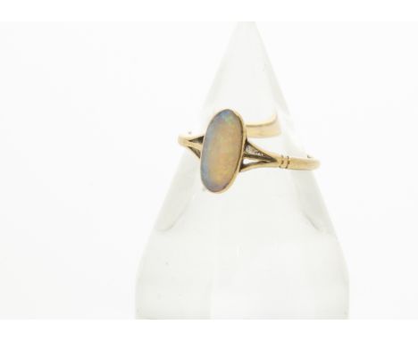 An 18ct gold opal dress ring, the elongated precious oval opal in rubbed over setting with pierced shoulders on a plain gold 