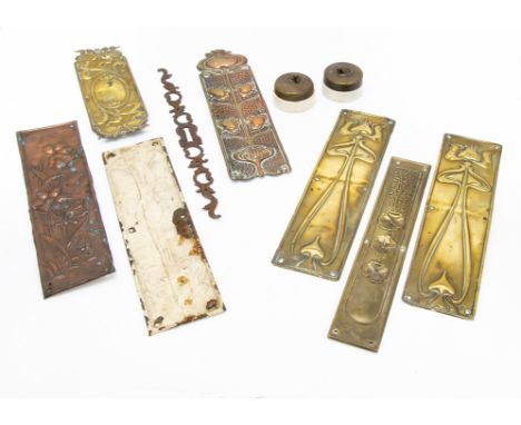 A collection of brass and copper Art Nouveau door furniture, including embossed finger plates, a pair of brass examples with 