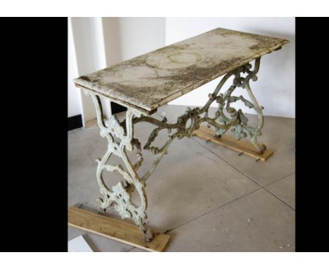 A marble topped garden table, the rectangular marble top supported on a cast iron frame of bracket arched design with central