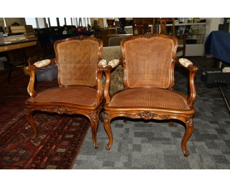 A pair of 19th Century continental walnut framed carved bergère armchairs, the single carved seat and curved back with carved