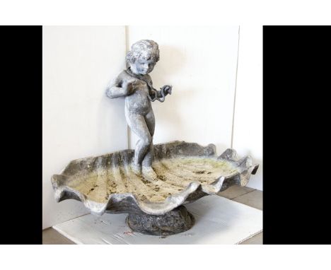 A 19th Century lead bird bath, modelled as a large conch shell with classical cherub standing playing with two snakes one wra