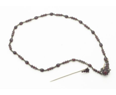 An early 20th Century foil backed continental garnet necklace, oval and circular faceted in claw and rubbed over settings, wi