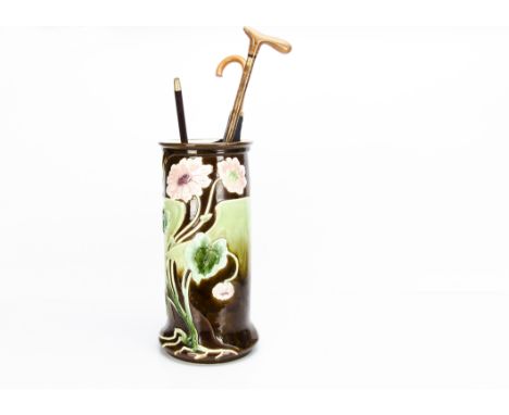 A large continental Art Nouveau majolica stick stand, of cylindrical form decorated with pink flowers, sinuous stems against 