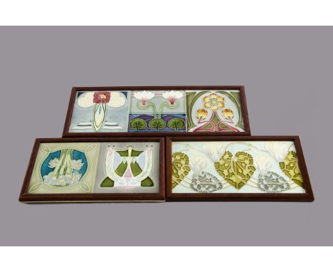 A set of three framed continental Art Nouveau tiles, relief moulded floral decoration glazed in colours within modern moulded