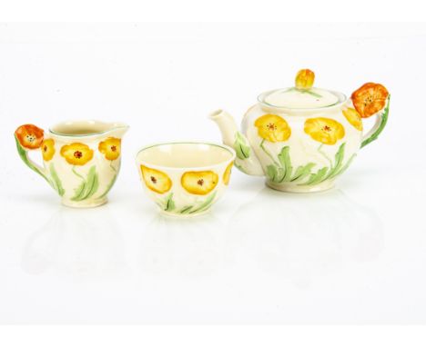 A Grindley Pottery Art Deco three piece teaset, the bachelor tea set with moulded yellow flower design with stylised moulded 