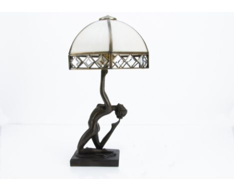 An Art Deco style resin figural lamp base, modelled as a nude female in a kneeling pose with arms outstretched supporting a f