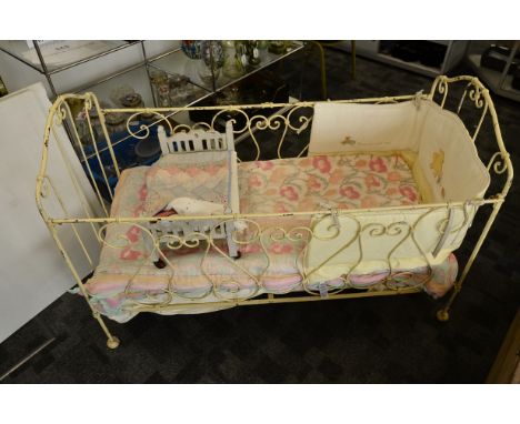 An iron painted child's cot, circa 1900, 61cm wide x 130cm x 89cm high, with contemporary Winnie the Pooh bumper and other te