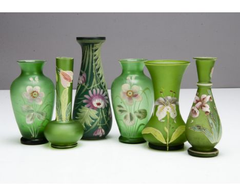 Six Art Nouveau green glass vases, all with painted decoration including a pair of ovoid vases with pink flowers 13.5cm high,