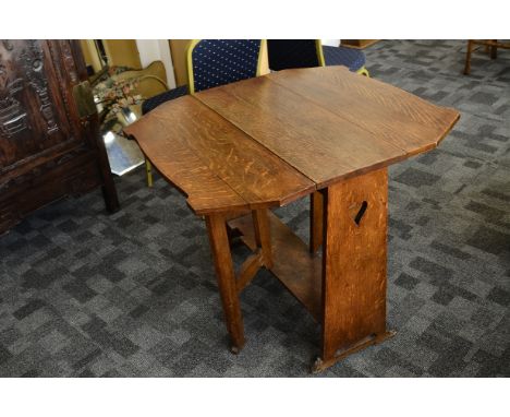 An oak Arts an Crafts drop leaf table,  the block side panels with pierced heart design supporting a hexagonal shaped top wit