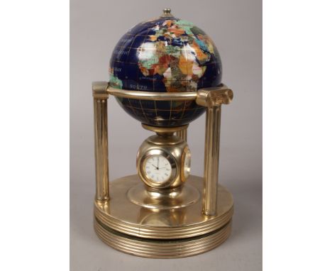 A hardstone set world globe, raised on brass ionic pillars with clock hygrometer and thermometer to the rotating base.