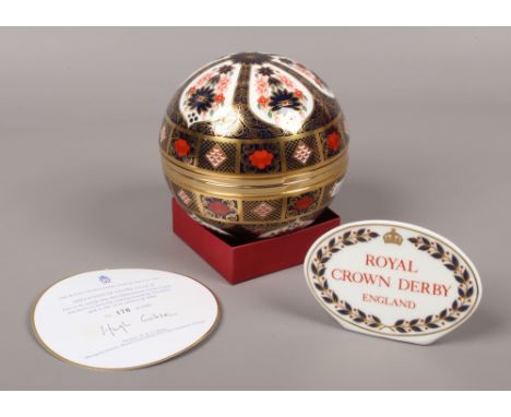 A Royal Crown Derby Millennium globe clock, along with a Royal Crown Derby porcelain sign.Condition report intended as a guid