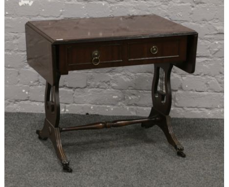 A mahogany drop end sofa table raised on lyre supports and brass lion paw feet.