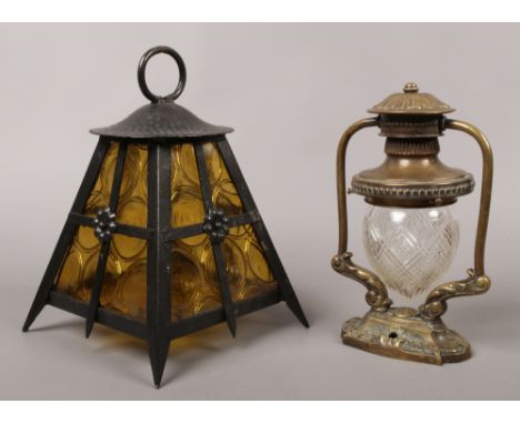 An ornate brass wall mount ships lantern with cut glass dome shade, along with a amber glass wrought iron porch lantern.