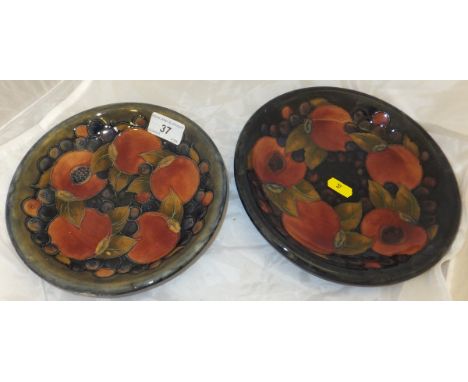 A Moorcroft pottery shallow dish decorated with pomegranate pattern on a mottled blue ground, a Moorcroft pottery shallow dis