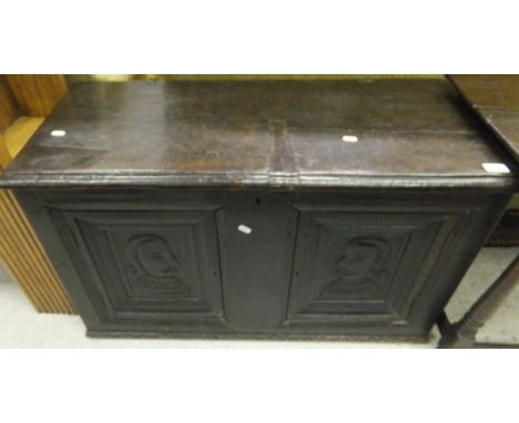 A 16th Century style oak coffer, the plain top above a pair of panels depicting portrait of a gentleman in profile (with alte