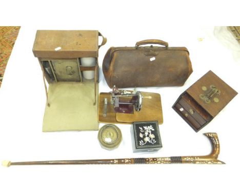 A box of miscellaneous items to include a miniature hand-operated sewing machine, a vintage leather cased picnic set containi