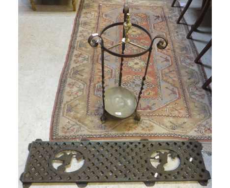 An iron and brass stick stand, and an iron grille decorated with humming birds