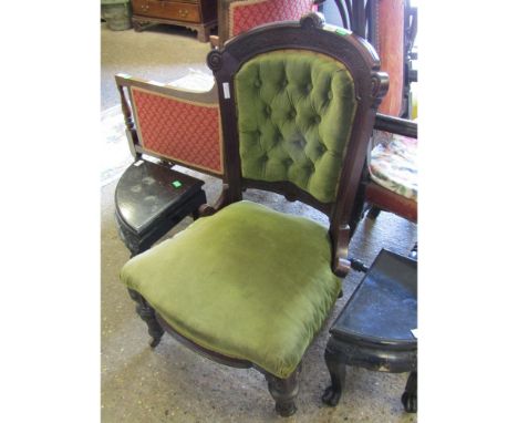 VICTORIAN MAHOGANY FRAMED NURSING CHAIR WITH GREEN UPHOLSTERY AND BUTTON BACK WITH TURNED FRONT LEGS RAISED ON PORCELAIN CAST