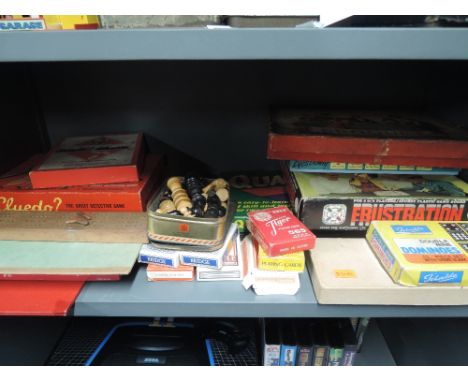 A shelf of vintage games and toys including Frustration, Table Top Croquet, Cluedo, chess pieces etc