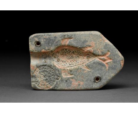 Ca. 700-800 AD A pentagonal-shaped hardstone panel with the carved impression of a fish-like creature with meticulously incis