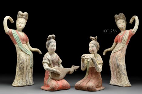 Ca. 618-907 AD  A delicate figure of a female dancer wearing a long flowing gown with her hands covered in sleeves. The top o