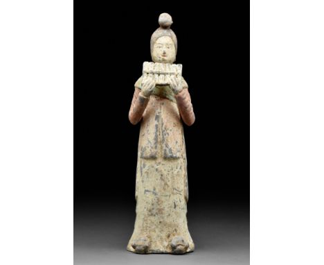 Ca. 618-907 AD  A mold-formed pottery tomb attendant figure in the form of a female musician playing paixiao - the wind instr