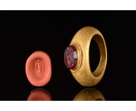 Ca. 100-300 AD  A beautifully formed gold ring of a round hoop with dramatically expanded shoulders and a carnelian oval inta