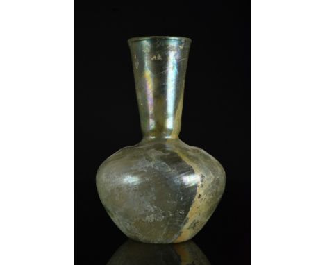 Eastern Mediterranean, Ca. 1-200 AD  A large pattern molded blown yellow-green glass bottle having a tapered bulbous body wit