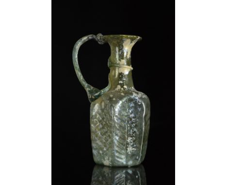 Ca. 100-300 AD  A splendid glass jug with a concave base with pontil scar, six sides on the body, each lovely decorated, a cy