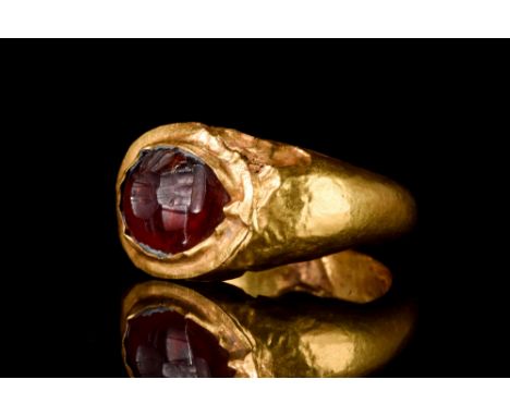 Ca. 100-300 AD  A beautifully formed hollow gold finger ring with expanding shoulders to support a bezel set with a large gar