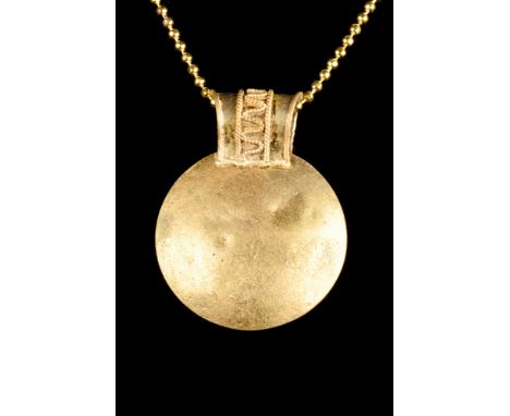 Ca. 100-300 AD  A gold bulla pendant comprising a strap suspension loop with extensive filigree decoration, including meander