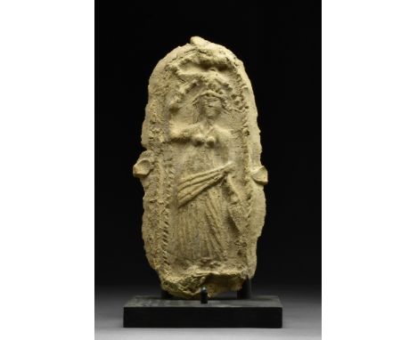 Ca. 100-300 AD  A terracotta relief with a low relief depiction of standing Goddess Tyche wearing a draped mantle over a chit