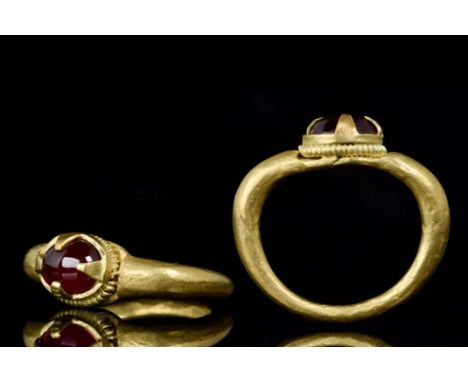 Ca. 8th-11th century ADA large finger ring having a heavy gold round tapered shank with a fine ringed border bezel and four l