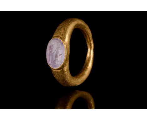 Ca. 100-200 AD  A gold finger ring of a hollow tapering hoop and a bezel set with an oval-shaped agate intaglio engraved with