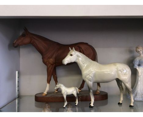 Wood mounted ceramic model horse along with two glazed ceramic model horses.