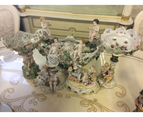 A selection of ceramic centre piece displays with cherub and floral decoration.