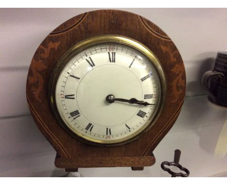 An inlaid wooden mantle clock.