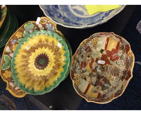 A set of green ceramic plates with sunflower design and an oriental dish.