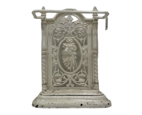 Victorian white painted cast iron stick or umbrella stand and drip-tray, the pierced back with central garland and scrolling 