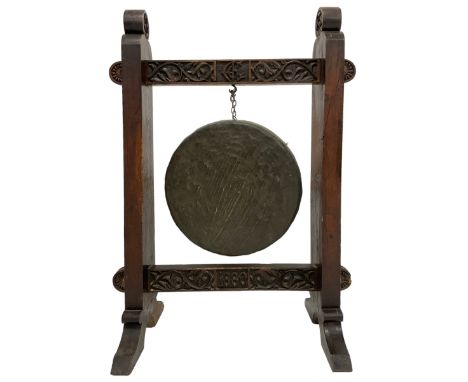Late 19th century carved oak frame gong on stand, the pegged frame carved with scrolling foliage and flower heads, tooled bro