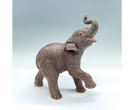 Part of the Smithsonian Institution collection; a naturalistic matte finish figure of an elephant with its trunk in the air. 