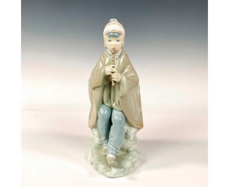 Glaze finish; molded as a young boy seated playing in harmony. Nao By Lladro backstamp. Dimensions: 3.75"L x 5.5"W x 9.75"HMa