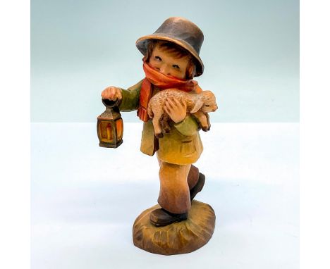 A vintage carved figure of a young boy carrying a sleeping lamb. Artist carved name on the side. Anri carved on the base. Art