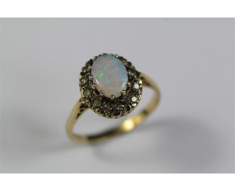 A 9ct Yellow Gold Diamond and Opal Ring. The opal approx 8 x 6mm, approx 12pts of 8 cut dias, size N+, approx 2.8 gms.