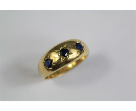 An 18ct Yellow Gold and Sapphire Ring. The set with approx 3 x 3.2mm sapphires, size R, approx 5.2 gms.