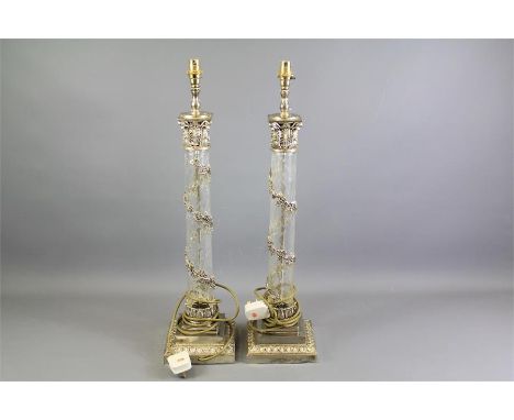 A Pair of Glass and Chrome Effect Lamp Bases. The tall lamp bases raised on square bases benefit from foliate garland decorat
