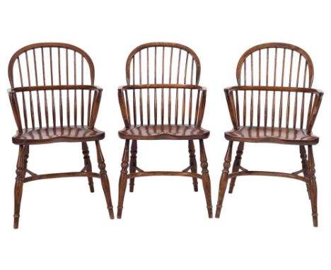 A set of three elm, ash and beech stick back Windsor elbow chairs in the 19th Century style:, with arched backs, shaped solid