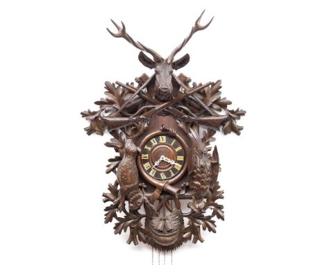 A large carved Black Forest cuckoo wall clock: the eight-day duration weight-driven movement striking on a gong with a cuckoo