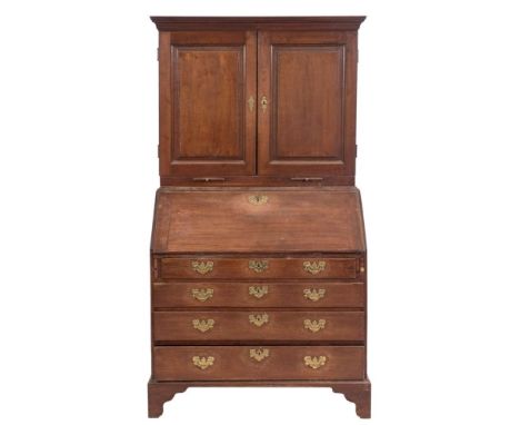 A mid 18th Century oak bureau cabinet:, the upper part with a moulded cornice, enclosed by a pair of fielded panel doors with