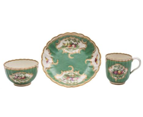 A First Period Worcester trio: of ribbed form decorated with bunches of fruit, foliage, trees and insects within gilt rococo 